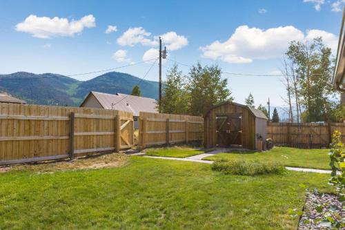 a wooden fence with a wooden shed in a yard at Cedars Cabin in Creede