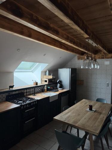 una cucina con tavolo in legno e una cucina con piano cottura di Appartement à la ferme ad Altenbach