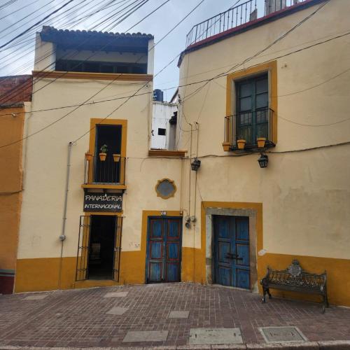 a building with blue doors and a bench in front of it at Doña Vicenta Casa Colonial in Guanajuato