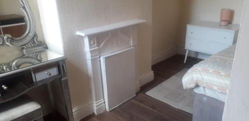 a room with a mirror and a bed and a dresser at Bright Home Guest House in Manchester