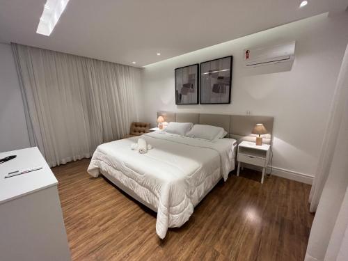a bedroom with a large white bed in a room at Casa 05 Monte Boa Vista - Casa de Luxo na Serra com Sauna e 4 Suítes in Teresópolis