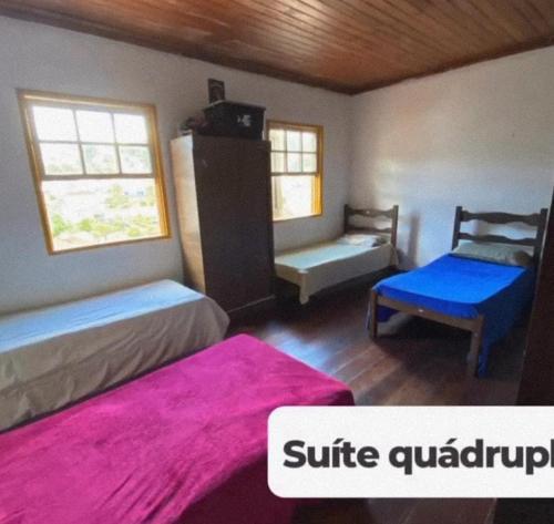 a bedroom with two beds and a chair and a couch at República Acrópole in Ouro Preto