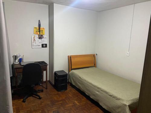 a bedroom with a bed and a desk and a desk at República Acrópole in Ouro Preto