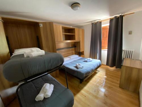 a room with two bunk beds and a couch at TEA San Pellegrino - DOLOMITI in Falcade