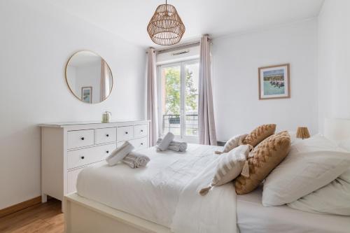 3 pièces proche de Paris avec terrasse et parking في شاتيلون: غرفة نوم بيضاء مع سرير كبير ومرآة