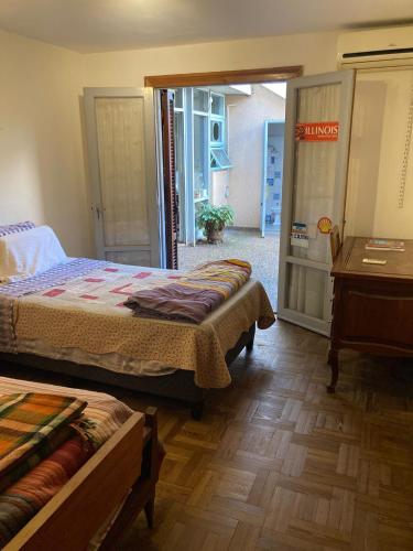 a bedroom with two beds and a table and a door at Habitación Privada "Central" in Salto
