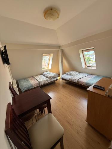 a room with two beds and a desk and a chair at Villa Aida in Mielno