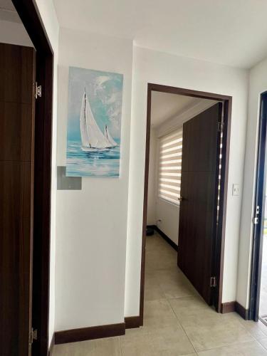 a hallway with a painting of a sailboat on the wall at Coralita in Jacó in Jacó