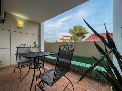 a balcony with a table and chairs and a pool at Madre Tierra Hotel & Coworking in Puerto Escondido