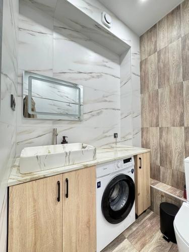 a bathroom with a washing machine and a sink at 2 room in the very center of the city near the mega park and walking distance to the Arbat in Almaty
