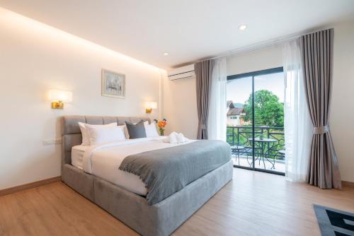 a bedroom with a bed and a balcony at At Bangla Patong Pool Moon villa in Patong Beach