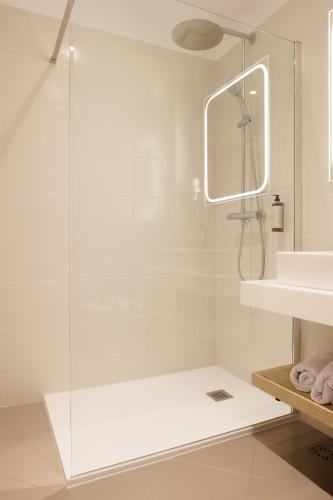 a white bathroom with a shower and a sink at Hotel Regal in Sinaia