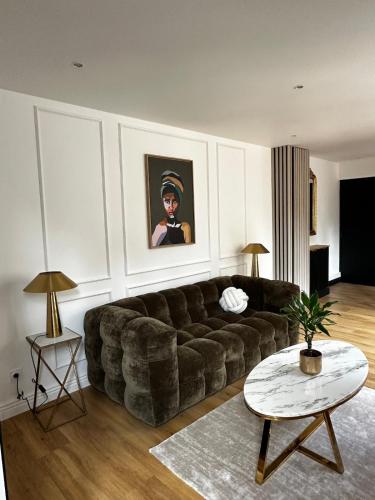 a living room with a large couch and a table at Le Paon D'Or - En plein coeur du Vieux Troyes in Troyes
