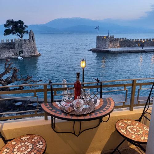 a table on a balcony with a view of the water at Casa da Sogno Elegant Studio in Nafpaktos