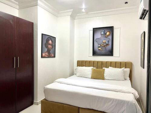 a bedroom with a bed and some pictures on the wall at 2 Bedroom in Lekki Phase 1 in Lekki