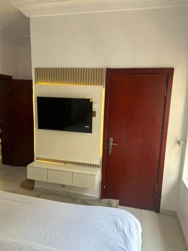 a bedroom with a flat screen tv on a wall at 2 Bedroom in Lekki Phase 1 in Lekki