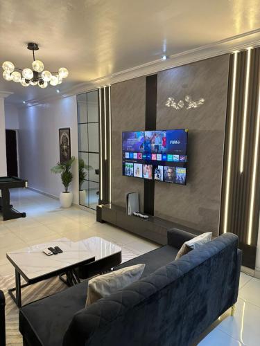 a living room with a couch and a flat screen tv at 2 Bedroom in Lekki Phase 1 in Lekki