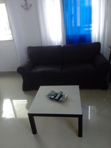 a living room with a black couch and a coffee table at Villa del mar in Bayahibe
