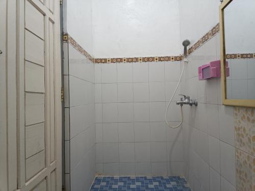 a bathroom with a shower with a toilet and a mirror at Hotel STIPRAM Kaliurang Yogyakarta in Kaliurang