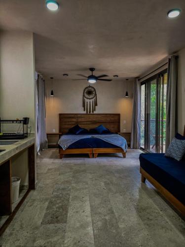 a bedroom with a bed and a ceiling fan at Loft Pelicano - Santuario Apartments in Chemuyil