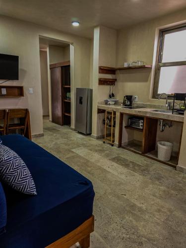 a room with a kitchen with a bed and a sink at Loft Pelicano - Santuario Apartments in Chemuyil