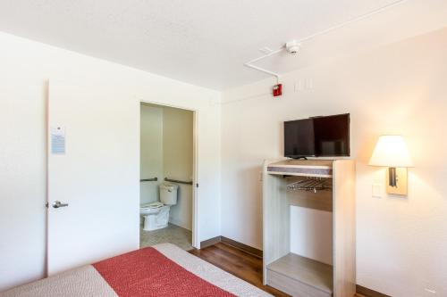 a room with a bed and a flat screen tv at Motel 6-Redding, CA - Central in Redding