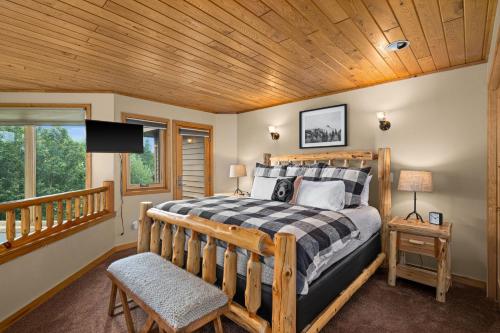 Un dormitorio con una cama y un techo de madera. en Gorgeous Executive Lutsen Townhome - Ski-in Ski-out, Pool, Hot Tub, Hiking, Biking, campfires and more!, en Lutsen