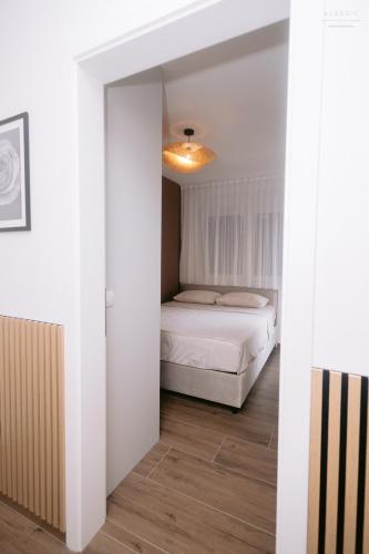 a bedroom with a bed in a white room at Stan na dan "Aparté" Brčko in Brčko