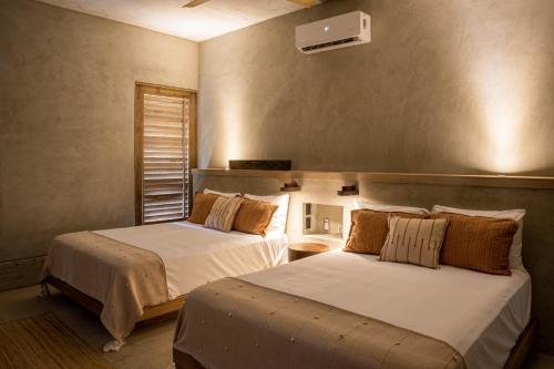 a bedroom with two beds and a window at Casa Miguana - Chiwiro in San Agustinillo