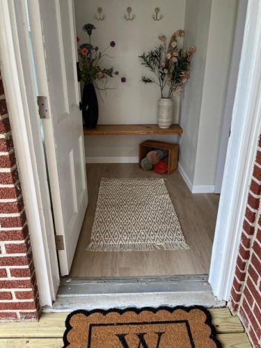 a hallway with a rug on the floor next to a door at The Rene Carr House in Elkton