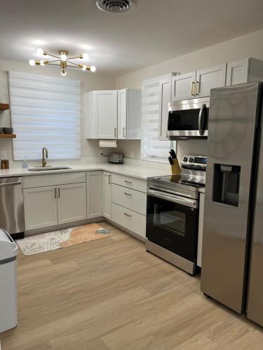 a kitchen with white cabinets and stainless steel appliances at The Rene Carr House in Elkton