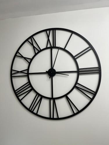 a black and white clock hanging on a wall at The Rene Carr House in Elkton