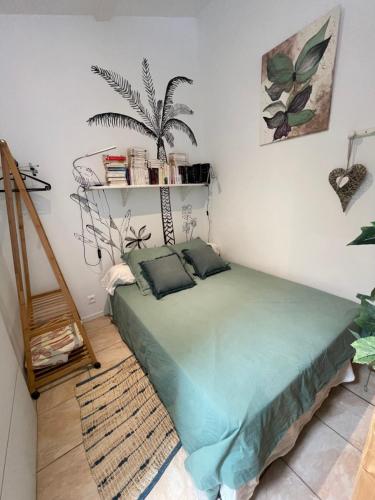 a bedroom with a green bed in a room at Studio cosy avec piscine privative in Saint-Sernin