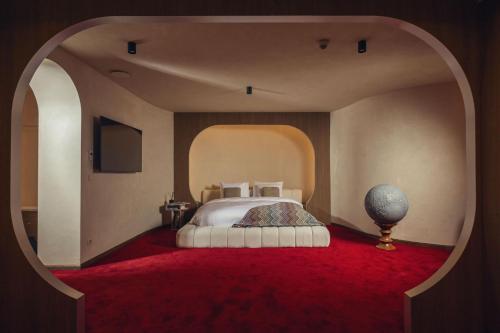 a bedroom with a large bed with a red carpet at La Butte aux Bois a Small Luxury Hotel of the World in Lanaken
