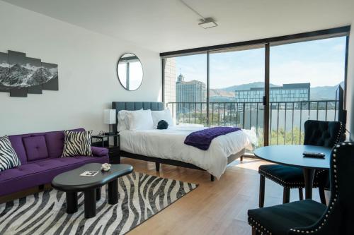 a bedroom with a bed and a purple couch at Cityscape Peaks Penthouse DT Gym Free parking in Salt Lake City