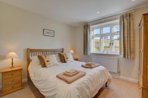 een slaapkamer met een groot bed met handdoeken erop bij Mill Cottage in Elsing