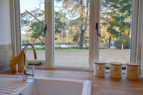 een aanrecht met een wastafel en een raam bij Mill Cottage in Elsing