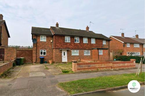 a brick house with a fence in front of it at 4 Bedroom spacious home with parking sleeps 9 in Hurley