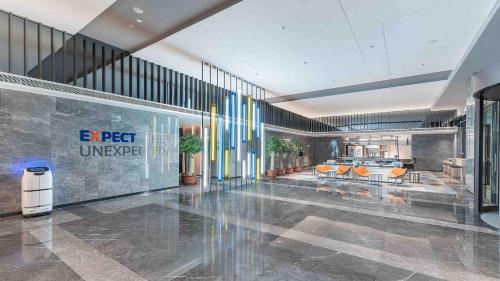 a lobby with chairs and tables in a building at Holiday Inn Express Foshan Shunde Lecong by IHG in Shunde