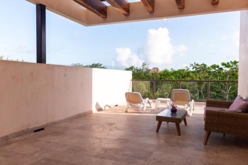 an open living room with chairs and a table at Loft Pelicano - Santuario Apartments in Chemuyil