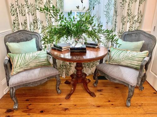 a table with two chairs and a table with a plant on it at Plantation House Bed & Breakfast in Port Hope