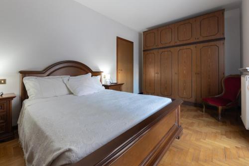 a bedroom with a large bed and a red chair at Monterosso-Cozy Apartment in CastellʼArquato