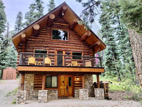 a log cabin in the woods with a balcony at Bear Hollow Cabin in Tacoma