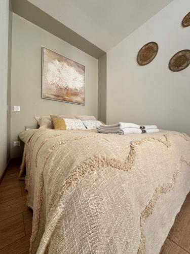a bedroom with a large bed with a painting on the wall at UrbanSoul Millau in Millau
