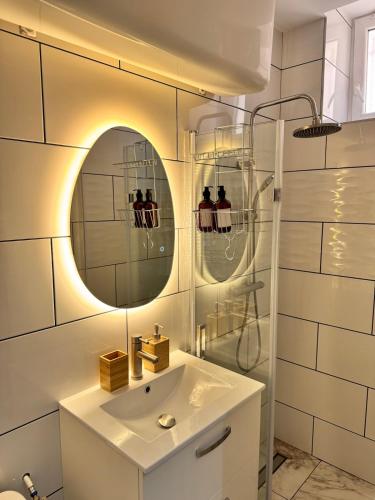 a bathroom with a sink and a mirror at UrbanSoul Millau in Millau