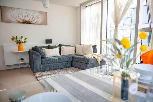 a living room with a couch and a large window at Mory Homes Modern 2 BDR Flat Private Parking in Central MK in Milton Keynes