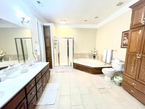 a bathroom with a tub and a sink and a toilet at Temple View Inn with Music Studio in Independence