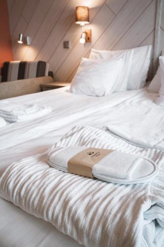 a white bed with two towels sitting on it at Hotel Rukatonttu in Ruka