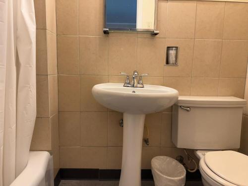 a bathroom with a sink and a toilet and a window at Tourest Motel in Peru