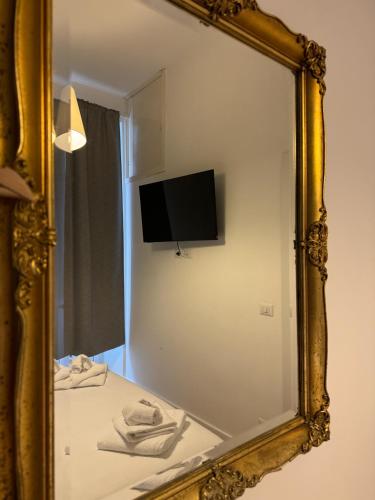 a mirror in a bathroom with a tv on the wall at NOI Luxury rooms Colosseum in Rome